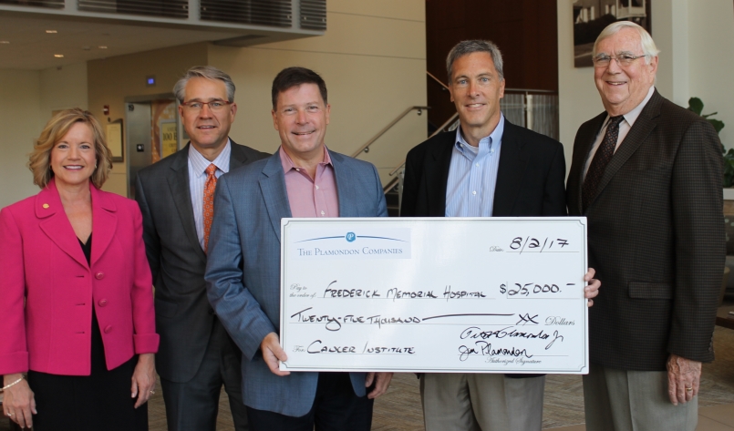 group of people holding a giant check